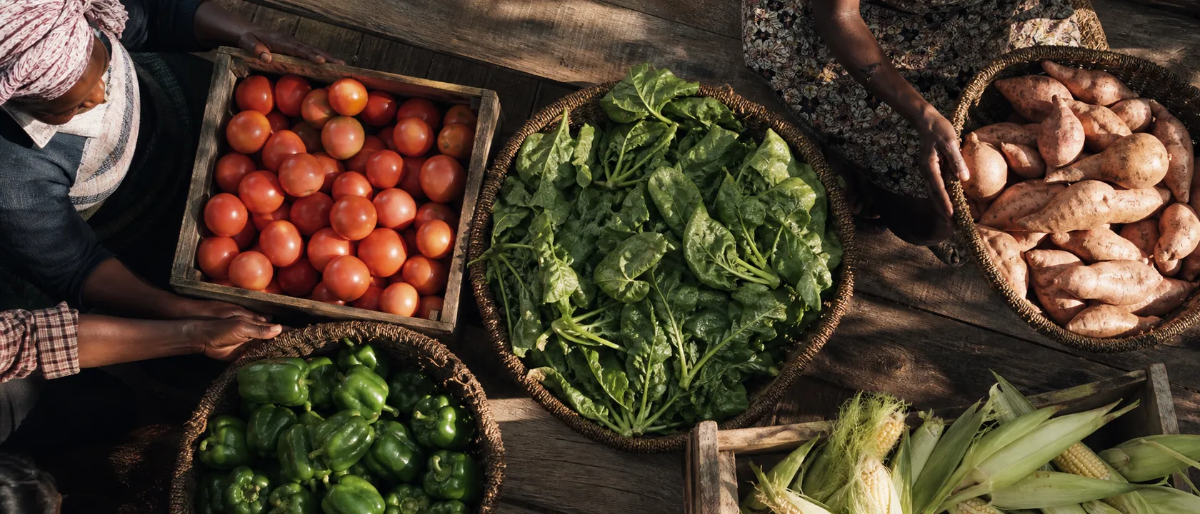 Freshly harvested vegetables in crates and baskets on a wooden table