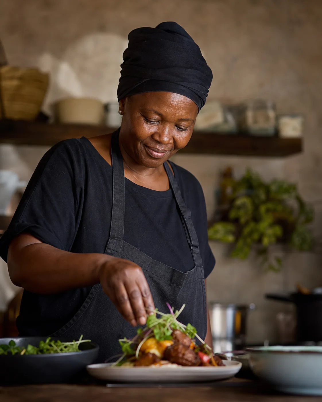 The cook plating a fresh meal at the Morwa Kitchen counter